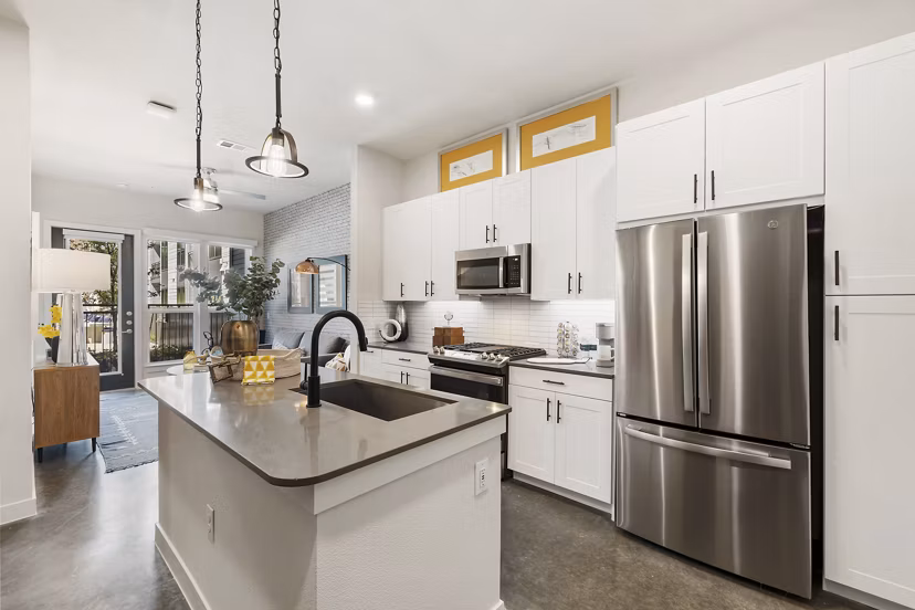 Modern kitchen with stainless steel appliances and granite countertops at Art House Sawyer Yards Apartments, a luxury living space in Houston