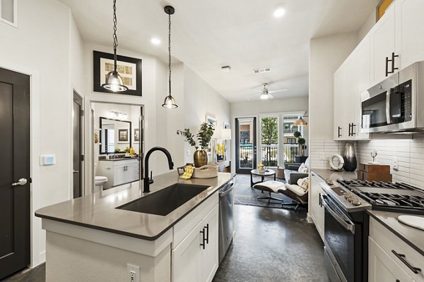 Kitchen featuring modern appliances and sleek countertops in Art House Sawyer Yards Apartments