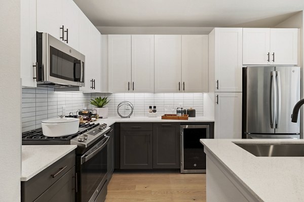 Kitchen with modern appliances and granite countertops at Art House Sawyer Yards Apartments, luxury residence in Houston