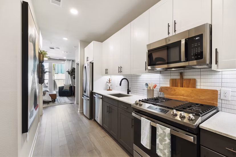 Modern kitchen featuring stainless steel appliances and sleek cabinetry in Art House Sawyer Yards Apartments luxury rentals