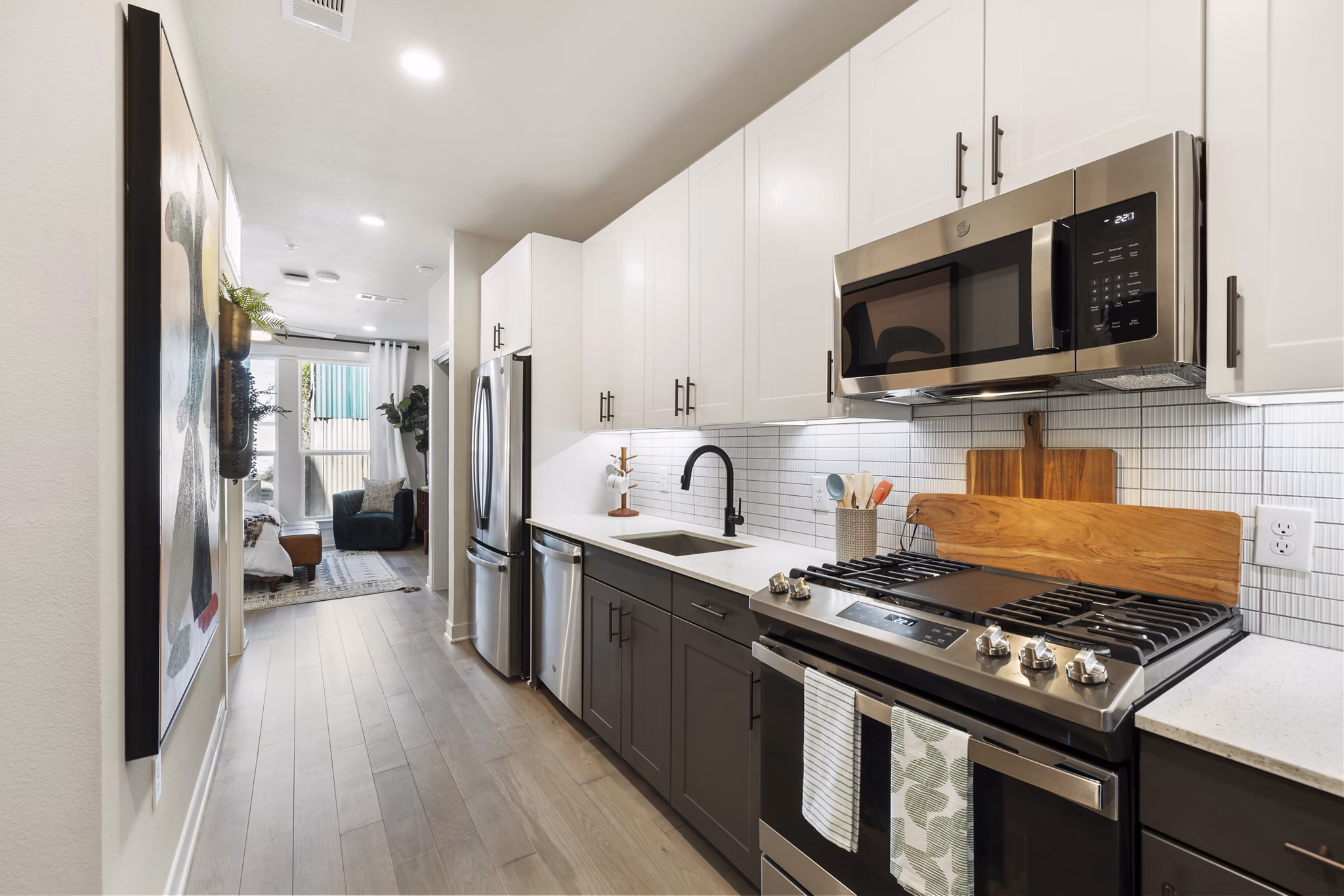 Modern kitchen featuring stainless steel appliances and sleek cabinetry in Art House Sawyer Yards Apartments luxury rentals