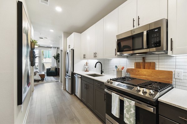 Modern kitchen featuring stainless steel appliances and sleek cabinetry in Art House Sawyer Yards Apartments luxury rentals