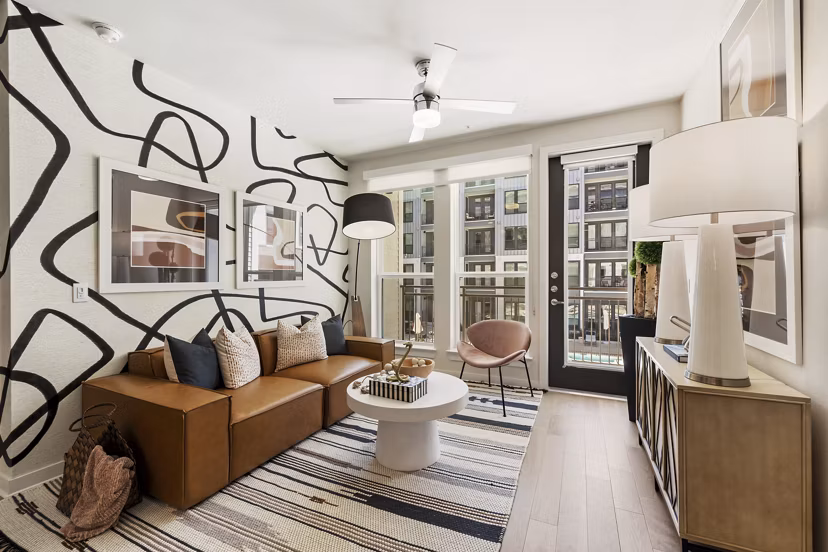 Spacious living room with modern decor and artistic accents in Art House Sawyer Yards Apartments