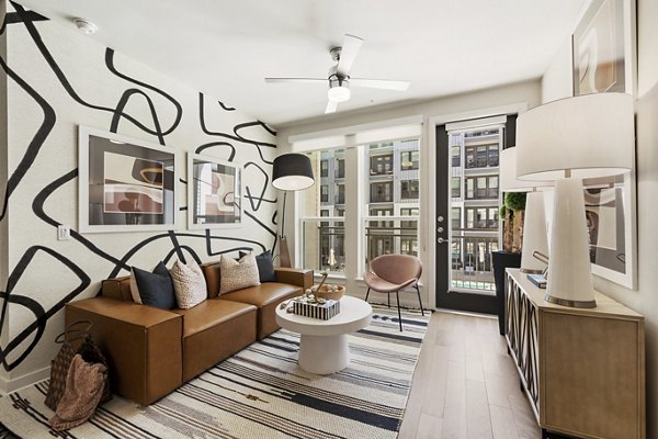 Spacious living room with modern decor and artistic accents in Art House Sawyer Yards Apartments