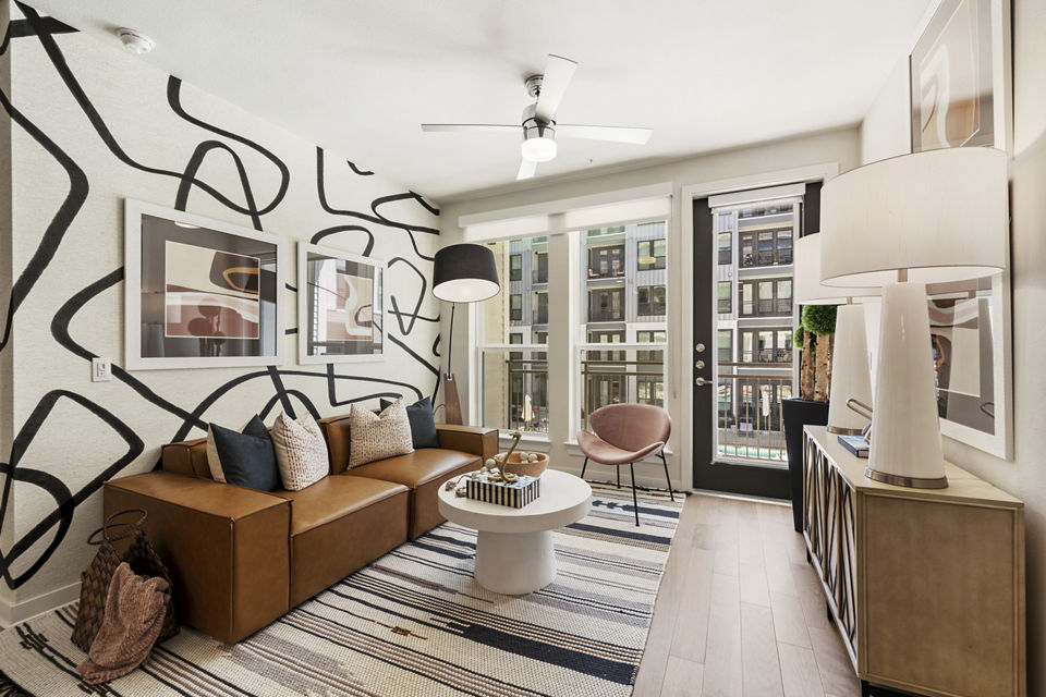 Spacious living room with modern decor and artistic accents in Art House Sawyer Yards Apartments