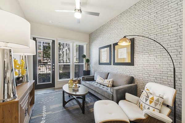 Living room with contemporary decor and large windows at Art House Sawyer Yards Apartments