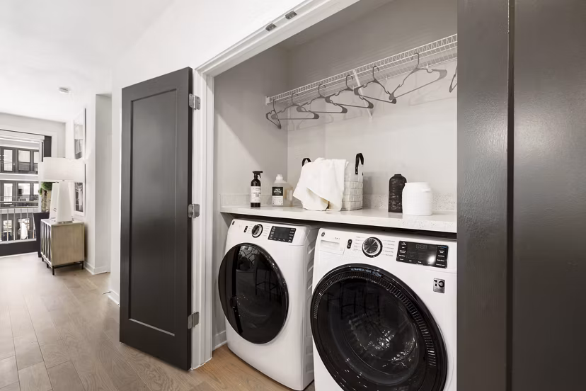 Laundry room with modern appliances at Art House Sawyer Yards Apartments