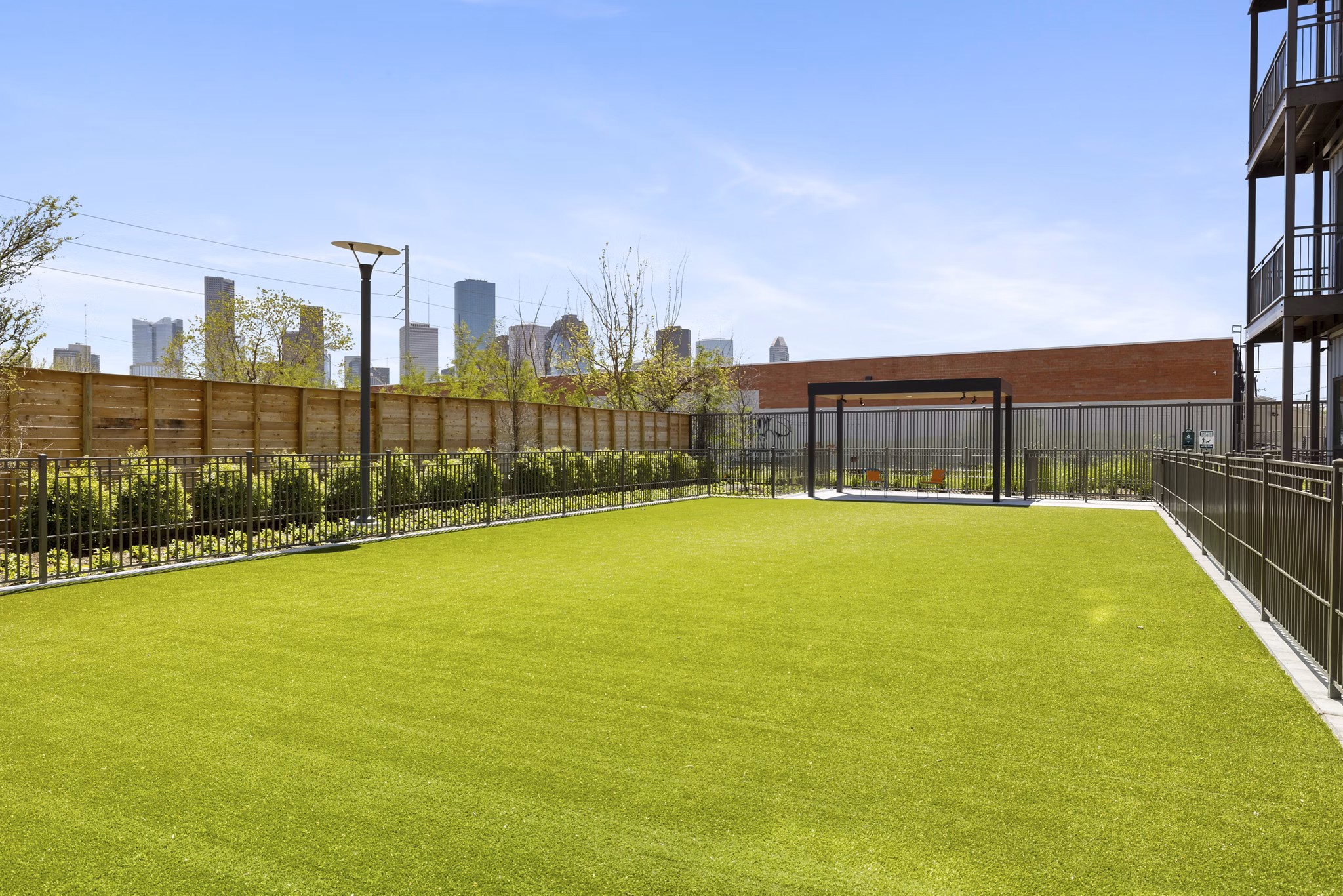 Spacious dog park equipped with agility features at Art House Sawyer Yards Apartments, providing a pet-friendly environment for residents