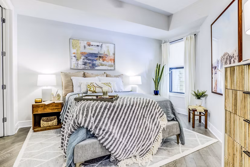 Cozy bedroom featuring modern decor and ample natural light at The Bowen Apartments