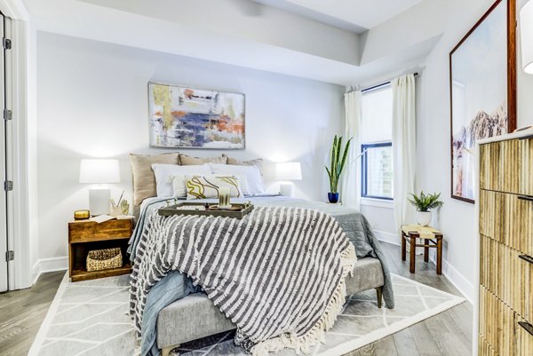 Cozy bedroom featuring modern decor and ample natural light at The Bowen Apartments