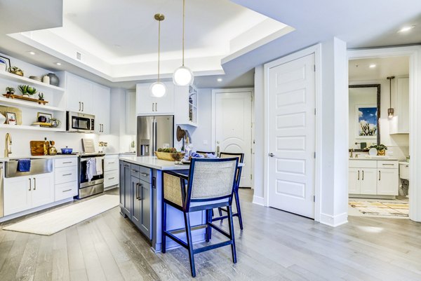 Modern kitchen featuring stainless steel appliances and granite countertops at The Bowen Apartments