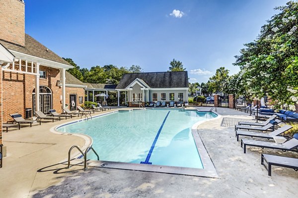 Relaxing outdoor pool at Avana on Broad Apartments with sun loungers and lush landscaping