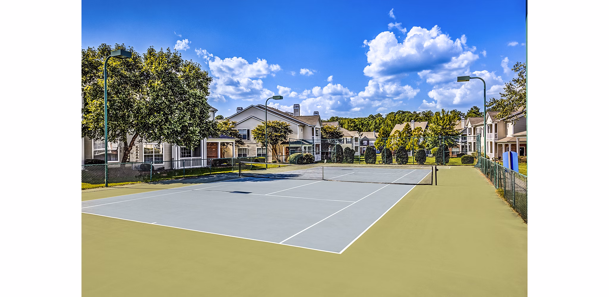 Tennis court with lush surroundings at Avana on Broad Apartments