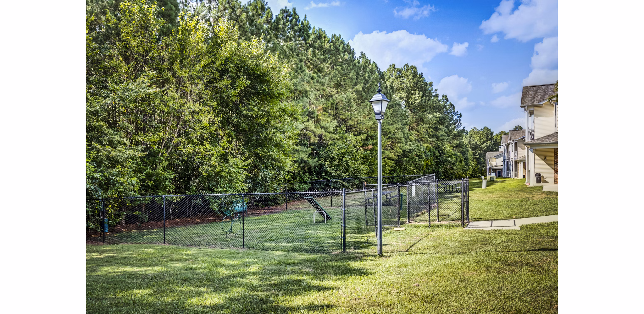 Fenced dog park with agility equipment at Avana on Broad Apartments, perfect for pet-friendly outdoor activities