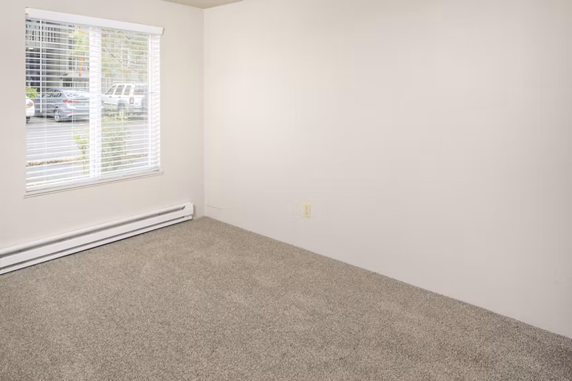 Cozy bedroom with modern decor and large window in Veri at Timberhill Apartments, luxury living in a serene setting
