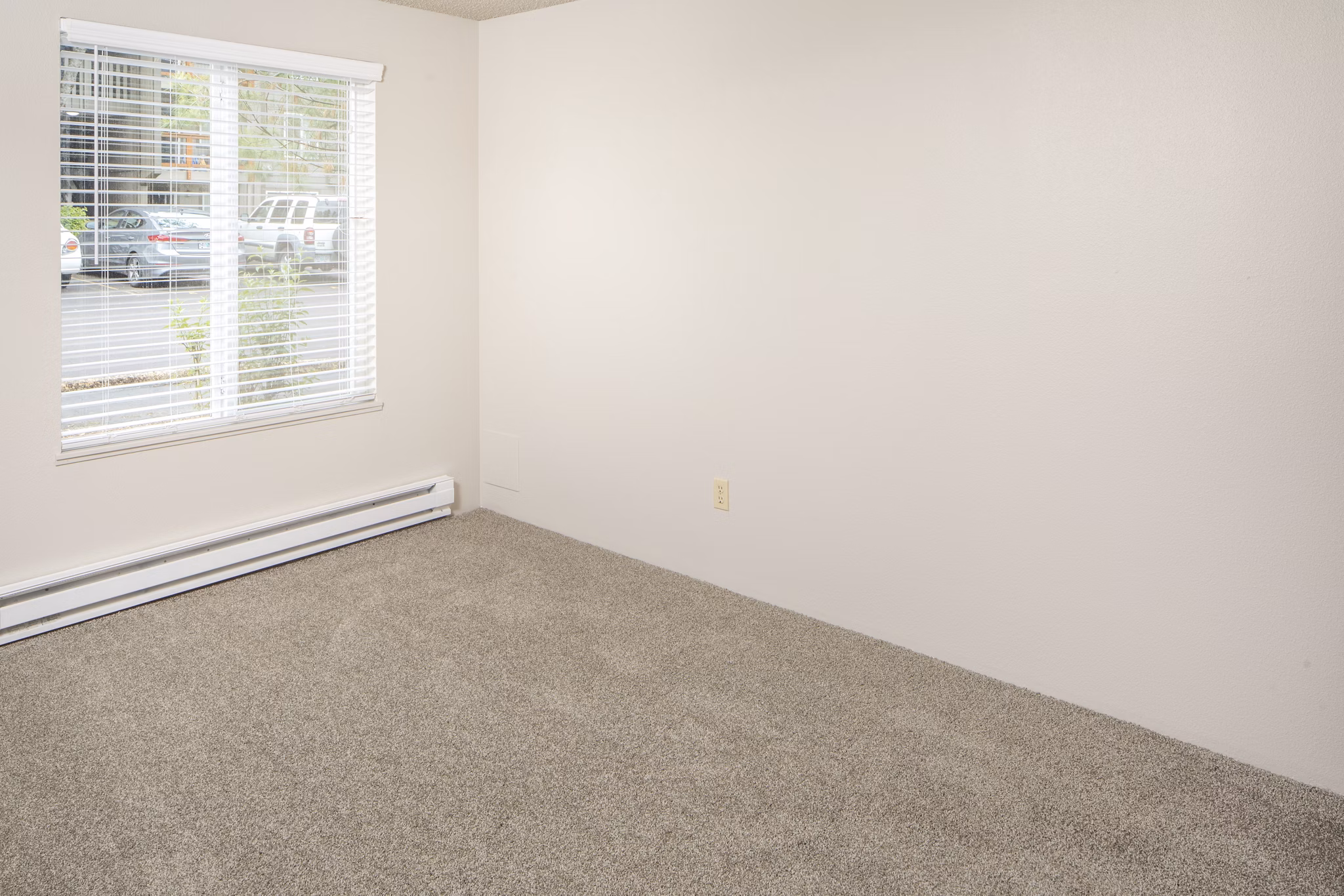 Cozy bedroom with modern decor and large window in Veri at Timberhill Apartments, luxury living in a serene setting