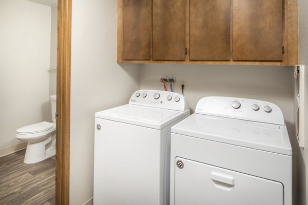 Laundry room with high-efficiency washers and dryers at Veri at Timberhill Apartments