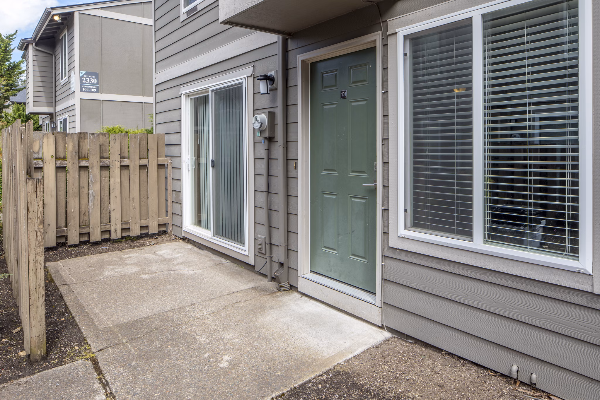 Spacious patio with seating and greenery at Veri at Timberhill Apartments for relaxation and outdoor dining