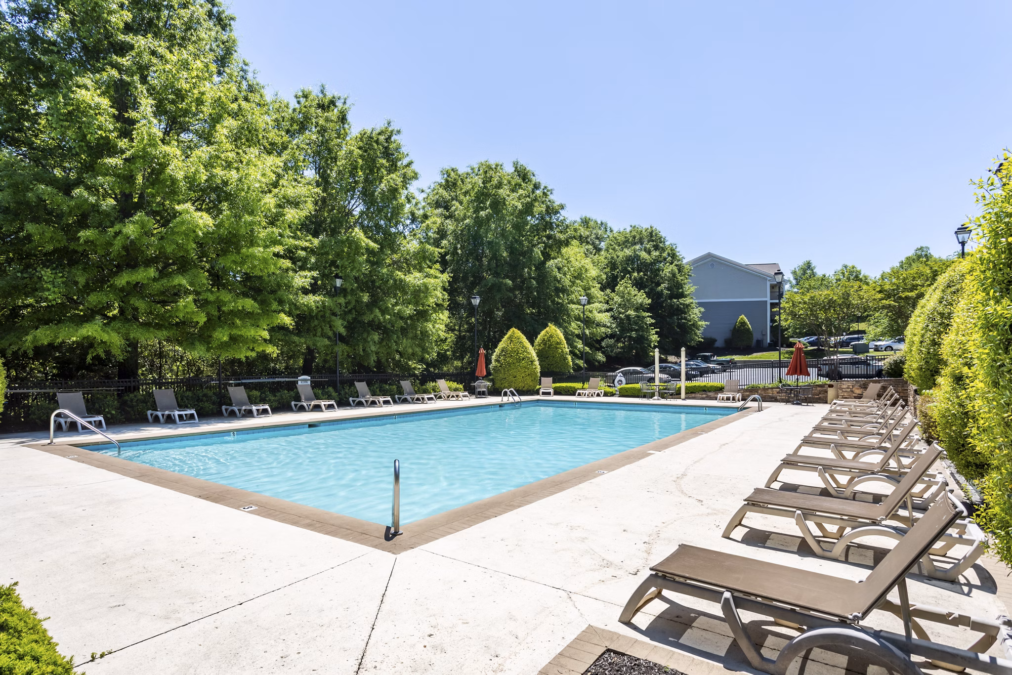 Resort-style pool with lounging chairs at Avana Overlook Apartments, offering luxury living with serene views