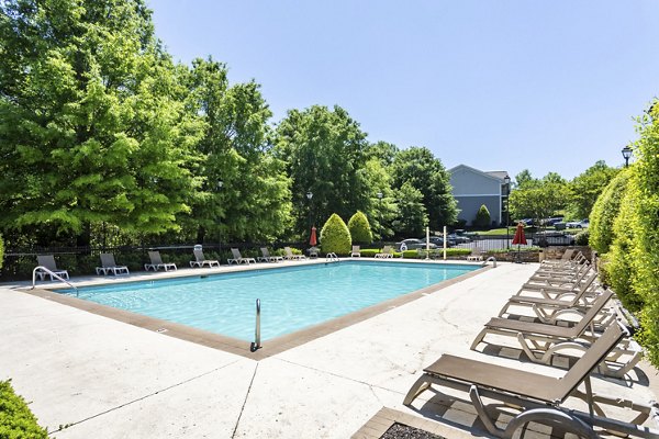 Resort-style pool with lounging chairs at Avana Overlook Apartments, offering luxury living with serene views