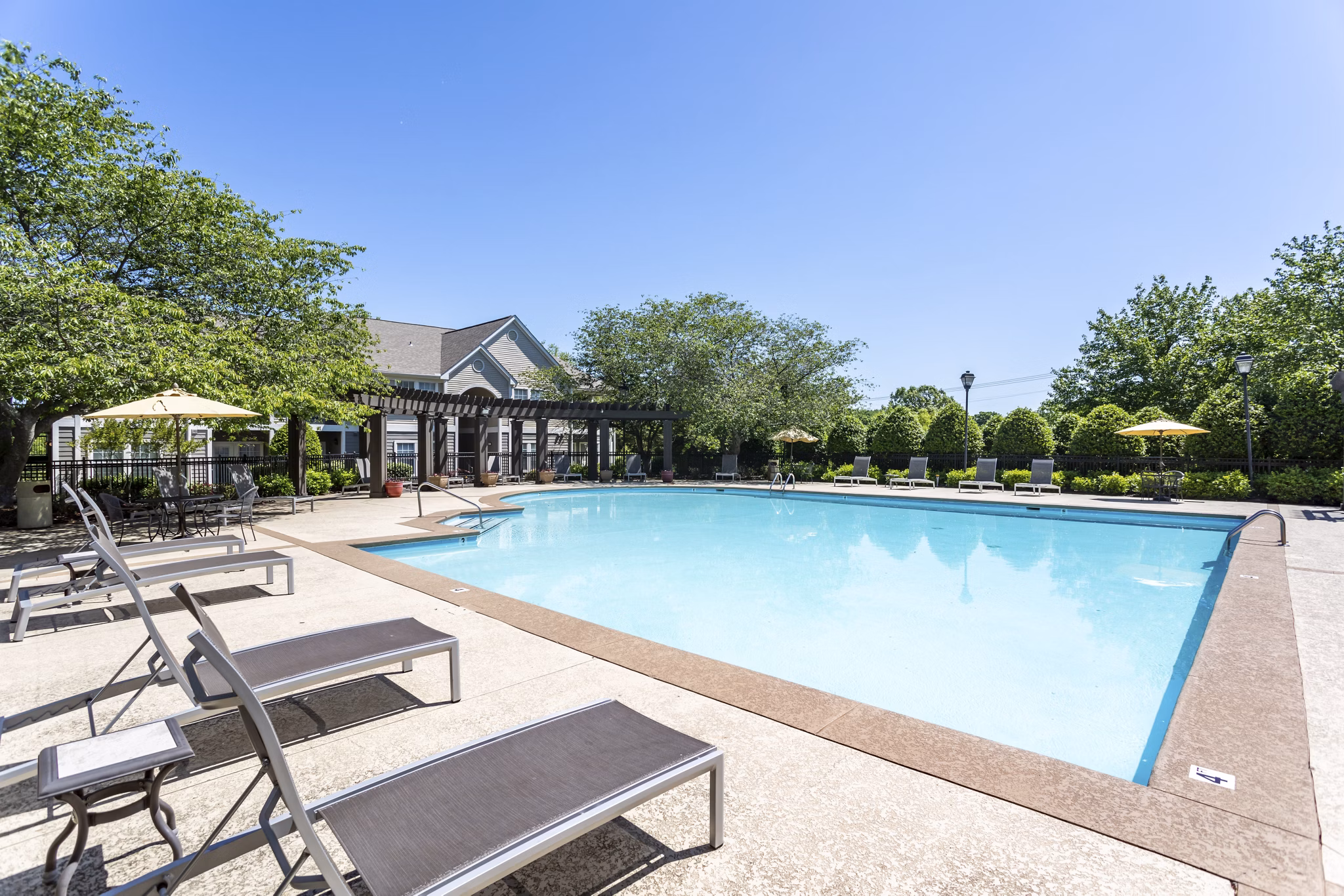 Resort-style pool with sun loungers at Avana Overlook Apartments, offering luxury living amenities for residents