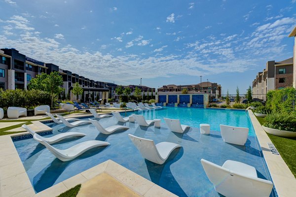 Resort-style pool with sun loungers at The Reflection at Montgomery Ridge luxury apartments