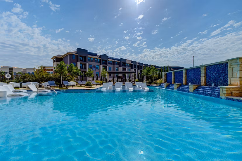 Modern outdoor pool with lounge seating at The Reflection at Montgomery Ridge Apartments, offering luxury relaxation spaces
