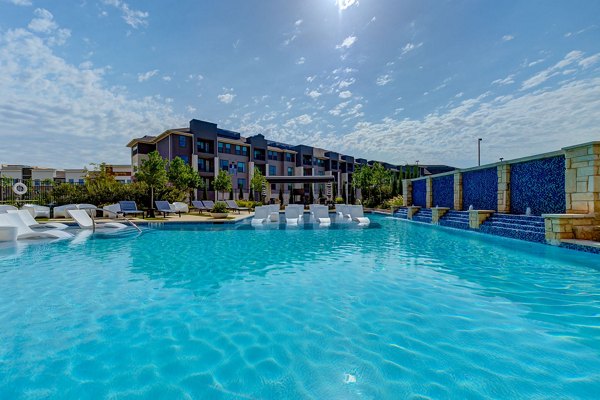 Modern outdoor pool with lounge seating at The Reflection at Montgomery Ridge Apartments, offering luxury relaxation spaces