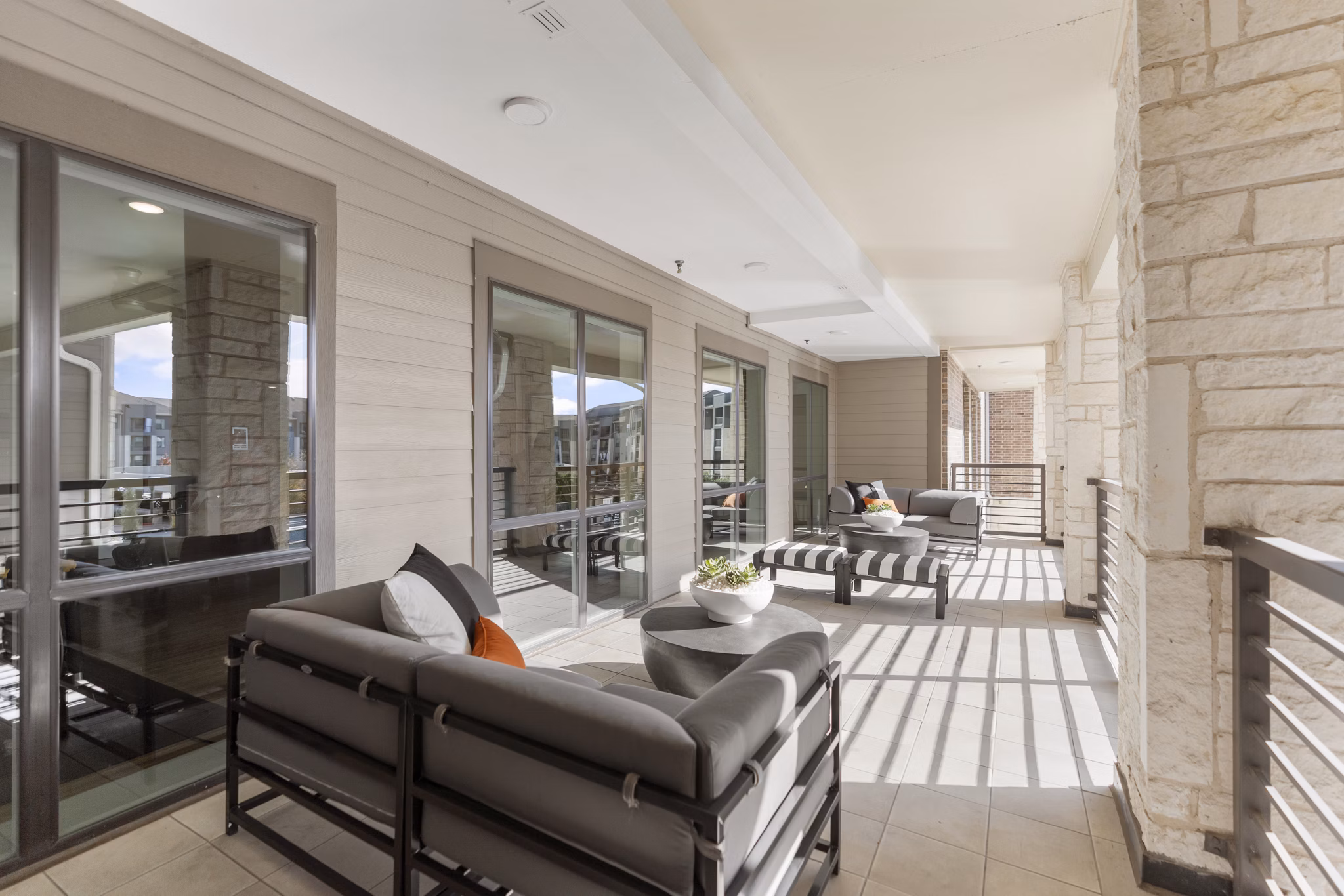 Spacious outdoor patio at The Reflection at Montgomery Ridge Apartments with modern seating and green landscaping