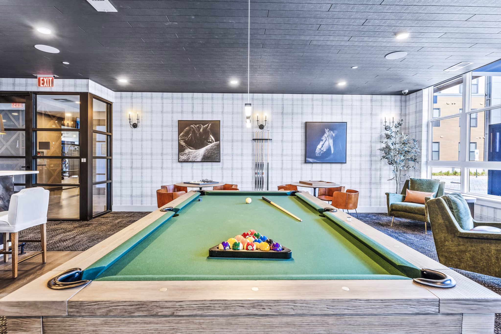 Recreation room with a pool table and vibrant wall art in luxury apartments