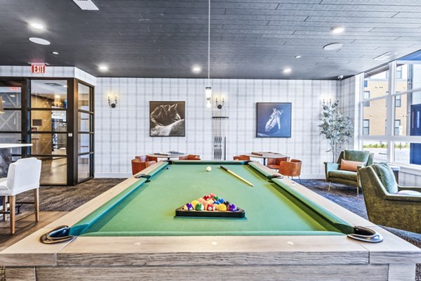 Recreation room with a pool table and vibrant wall art in luxury apartments