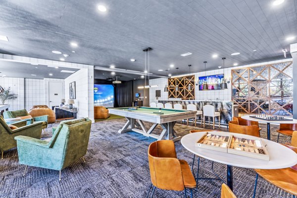 Modern game room with pool table and lounge seating at Canter Green Apartments