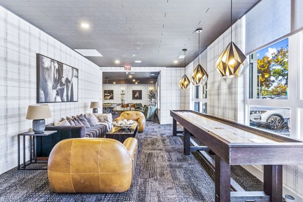 Game room with pool table and lounge chairs at Canter Green Apartments, featuring luxury amenities for resident entertainment and enjoyment