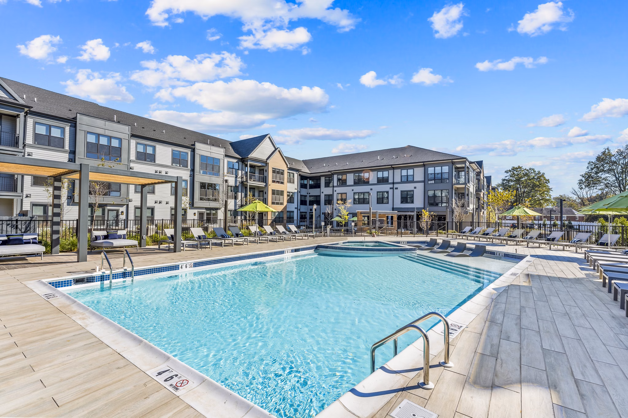 Outdoor pool with sun loungers at Canter Green Apartments