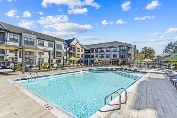 Outdoor pool with sun loungers at Canter Green Apartments