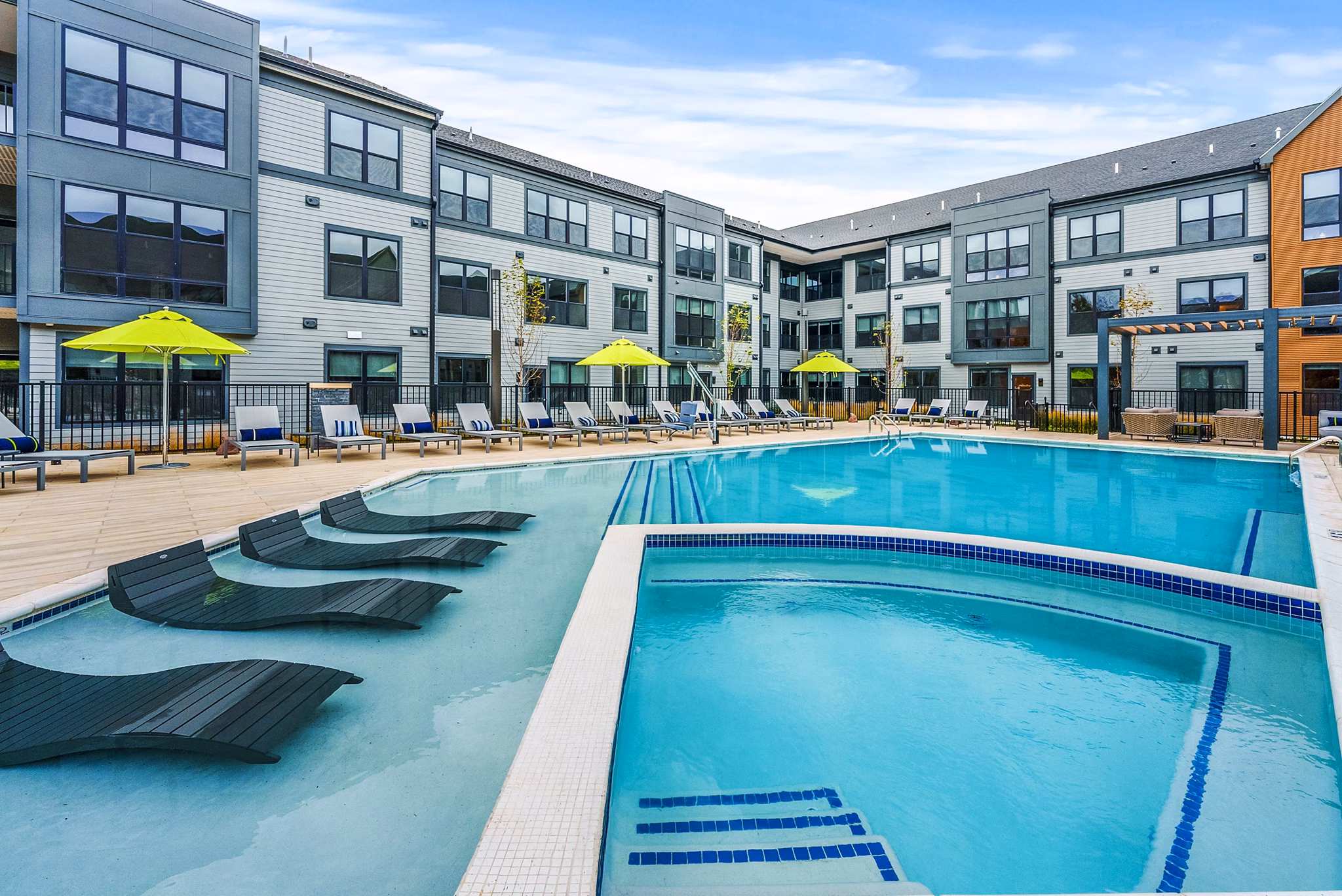 Poolside oasis with sun loungers and palm trees at Canter Green Apartments