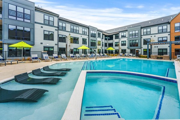 Poolside oasis with sun loungers and palm trees at Canter Green Apartments