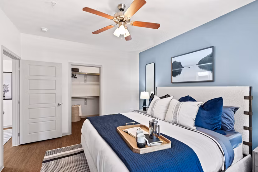 Cozy bedroom with large windows and modern furnishings at Creekside Townhomes Apartments