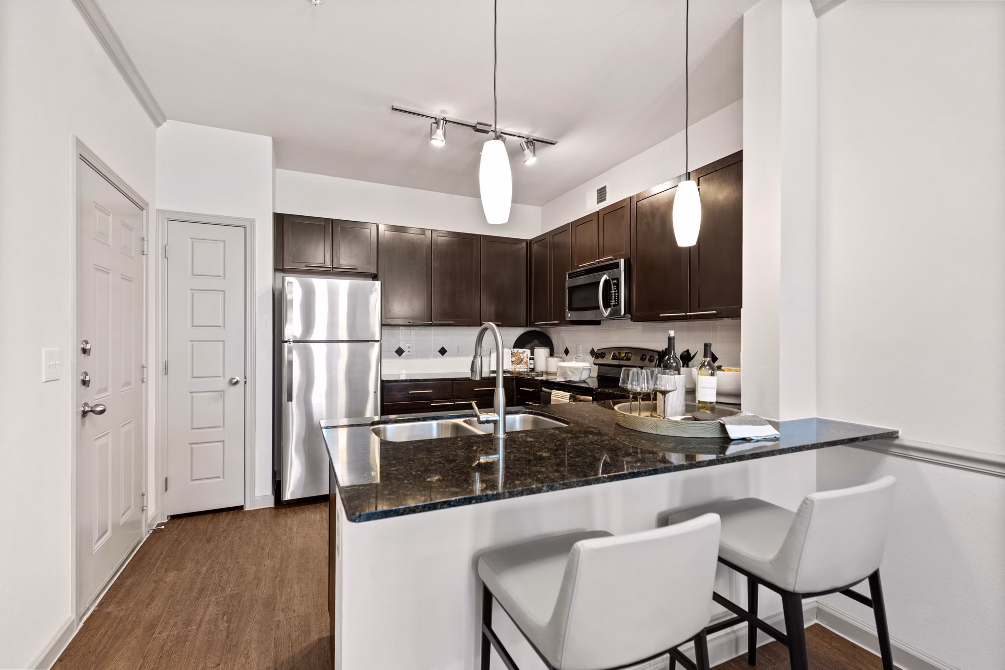 Modern kitchen with granite countertops and stainless steel appliances in Creekside Townhomes Apartments