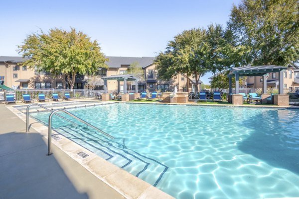 Outdoor pool with lounge chairs at Creekside Townhomes Apartments, a luxury residence offering serene waterfront views