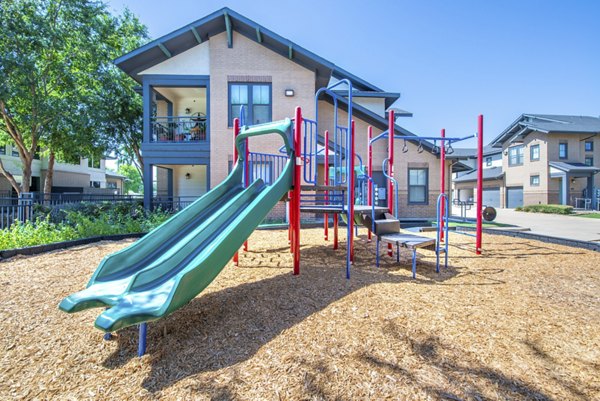 Modern playground with colorful slides and swings at Creekside Townhomes Apartments