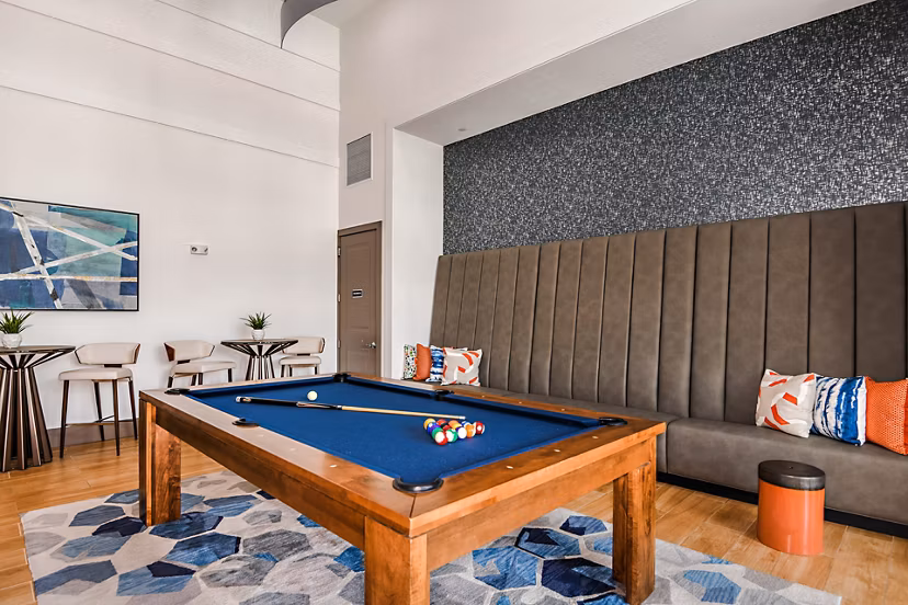 Clubhouse game room featuring pool table and cozy seating at Encore Metro at Millenia Apartments