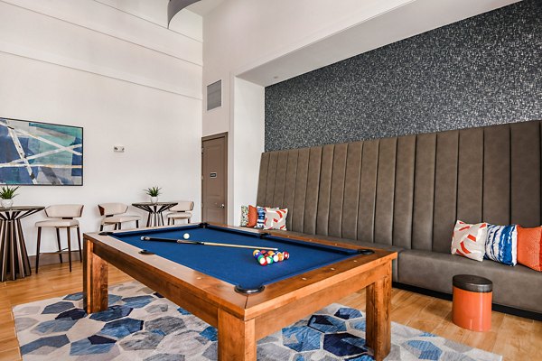 Clubhouse game room featuring pool table and cozy seating at Encore Metro at Millenia Apartments