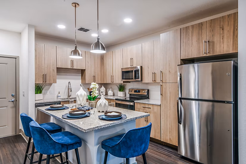 Modern kitchen with island and stainless steel appliances at Encore Metro at Millenia Apartments