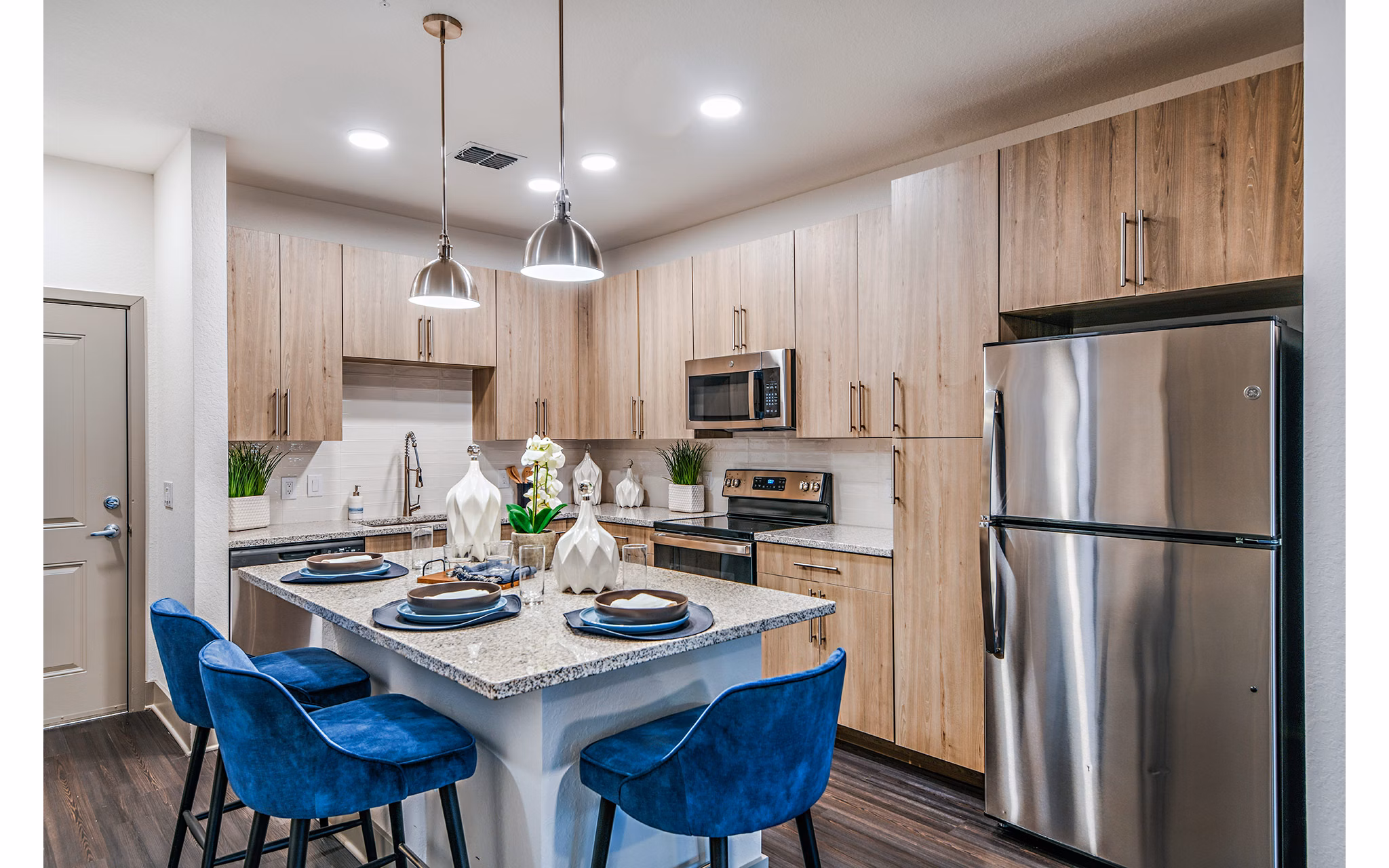 Modern kitchen with island and stainless steel appliances at Encore Metro at Millenia Apartments