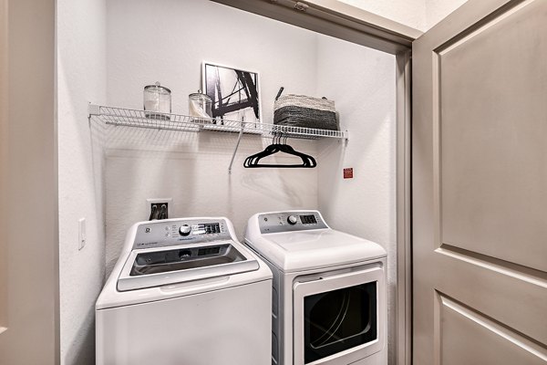Laundry room featuring modern washers and dryers at Encore Metro at Millenia Apartments