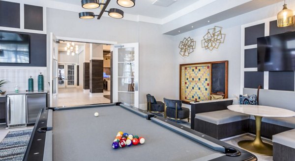 Clubhouse game room with billiards and seating at Residences at Shiloh Crossing Apartments