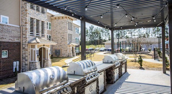 Grill area with modern patio furniture at Residences at Shiloh Crossing Apartments