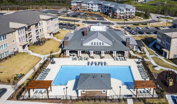 Relaxing outdoor pool at Residences at Shiloh Crossing Apartments with poolside seating and lush landscaping