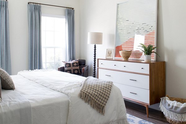 Cozy bedroom with modern decor at Carrington at Schilling Farms Apartments, offering luxury living in a serene setting